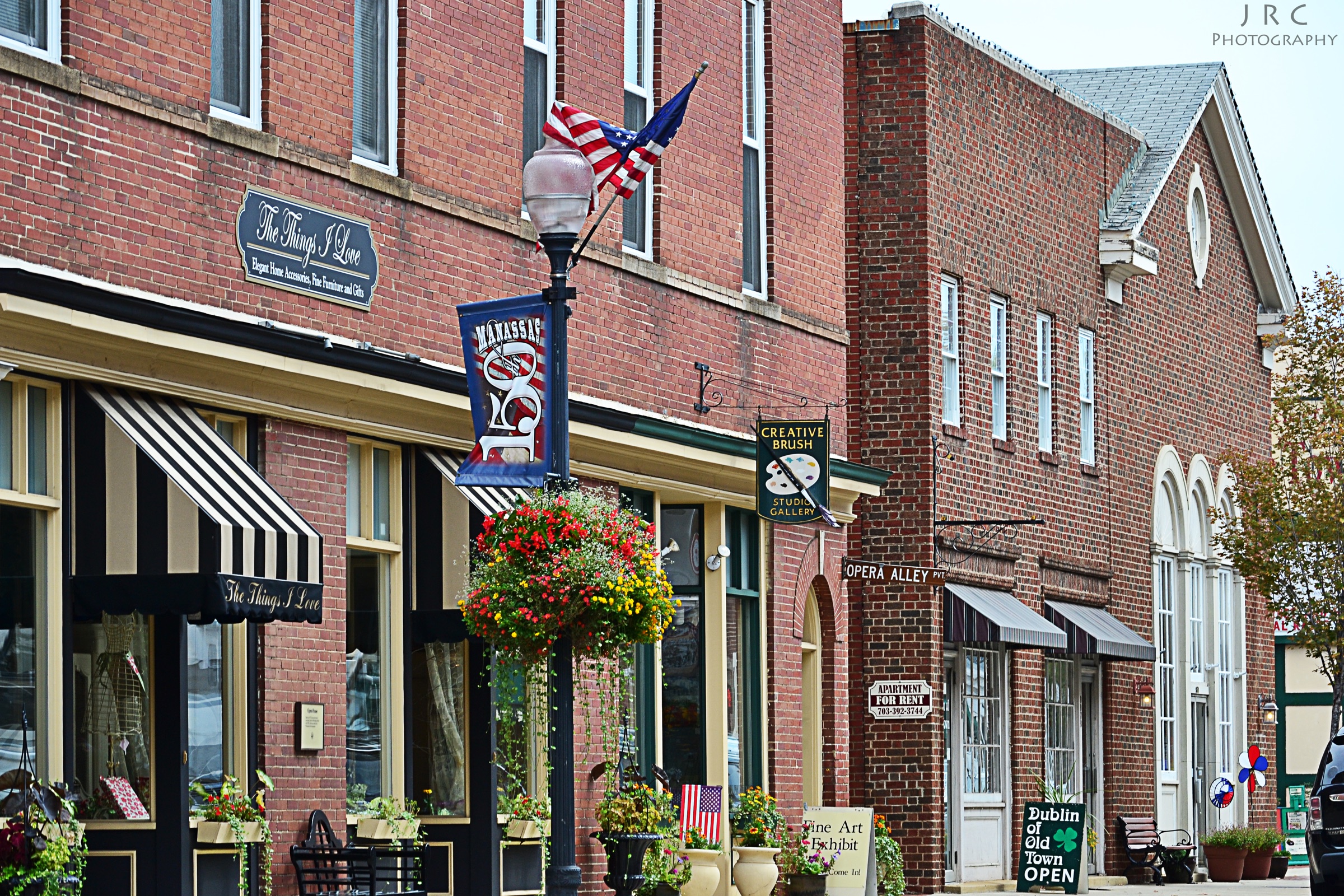 Brick storefronts and hanging flowers on Center Street in Old Town Manassas