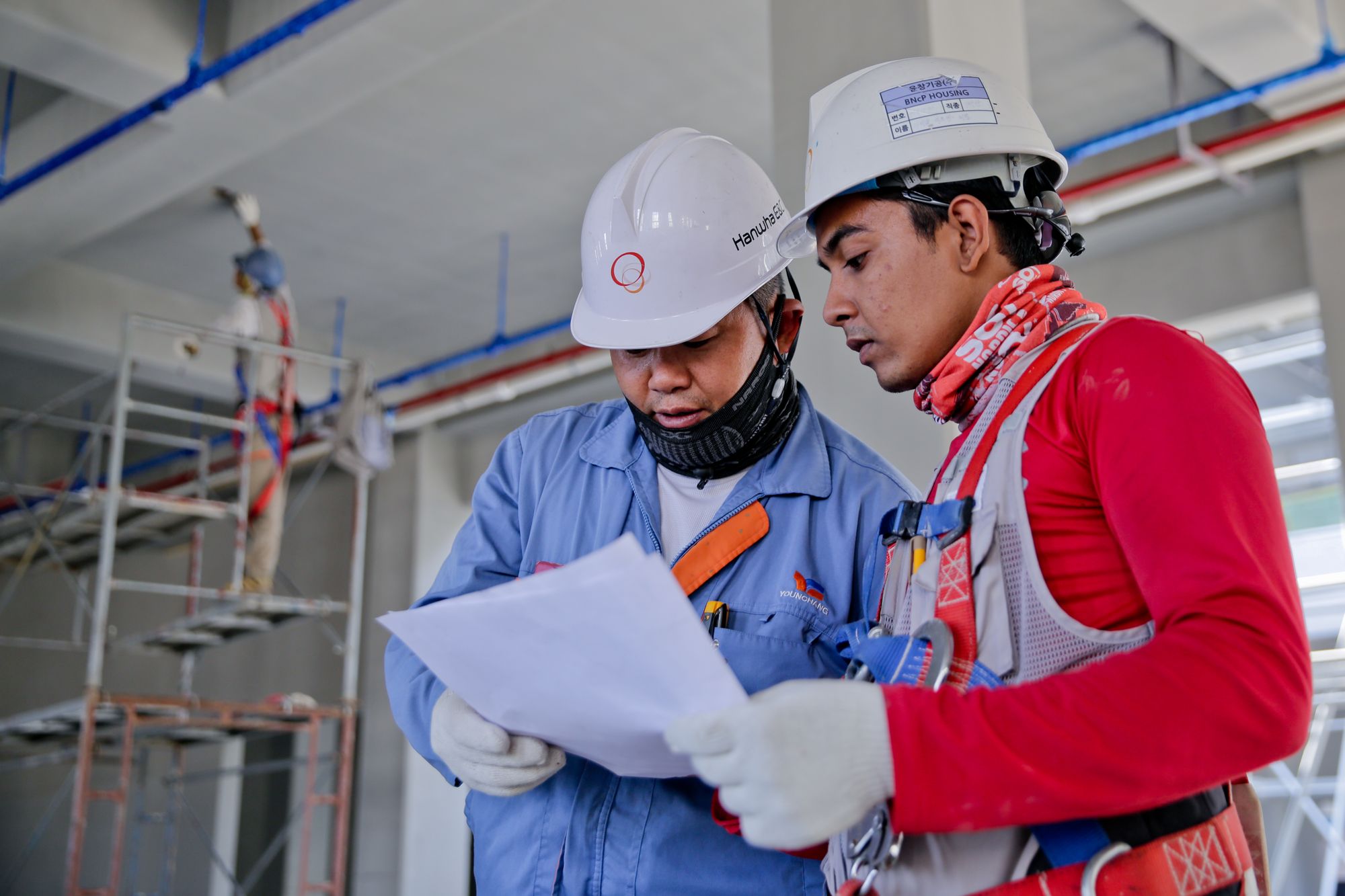 Two construction workers reviewing plans on site